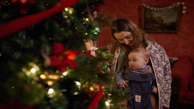 Mother and baby looking at a Christmas tree at Mompesson House, Wiltshire